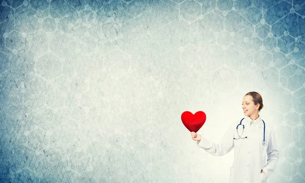 Young woman doctor  holding red heart — Stock Photo, Image