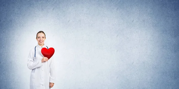 Young woman doctor  holding red heart — Stock Photo, Image