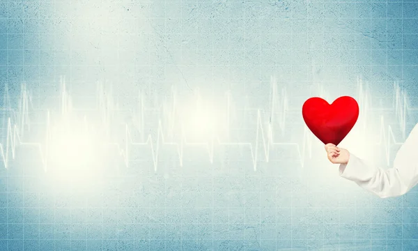 Доктор держит красное сердце — стоковое фото