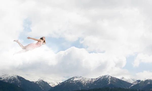 Kvinna som flyger högt i blå himmel — Stockfoto