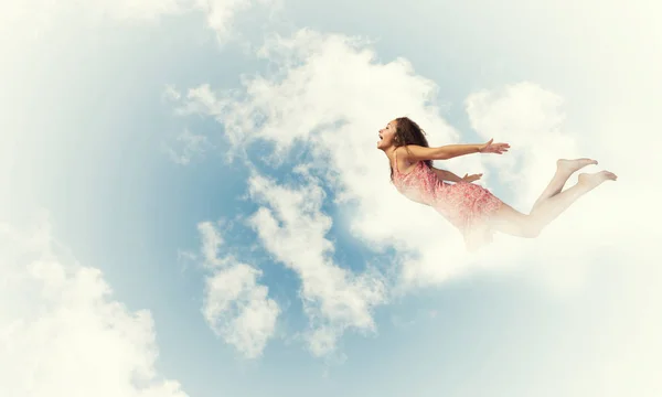 Woman flying high in blue sky — Stock Photo, Image