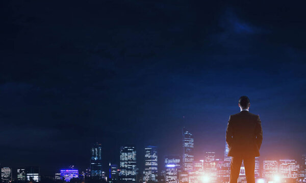 Businessman viewing night glowing city