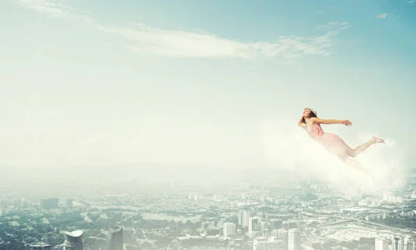 Woman flying high in blue sky — Stock Photo, Image