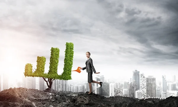 Attractive businesswoman watering plant — Stock Photo, Image