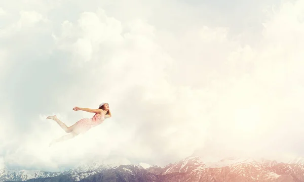 Woman flying high in blue sky — Stock Photo, Image