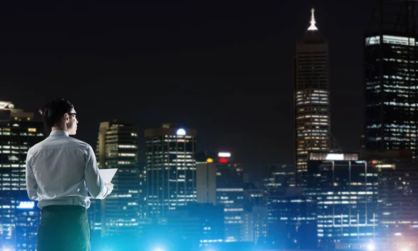 Biznesmen oglądanie miasta świecące w nocy — Zdjęcie stockowe