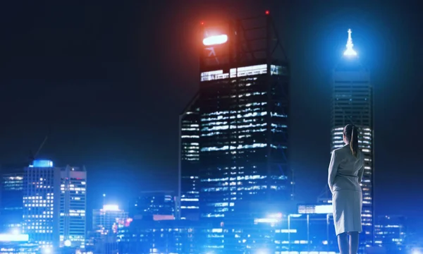Businesswoman viewing lights of night city — Stock Photo, Image