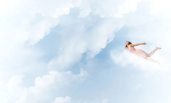 Mulher voando alto no céu azul — Fotografia de Stock