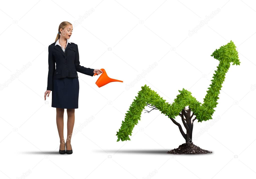 attractive businesswoman watering plant