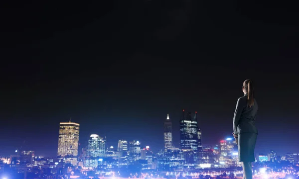 Femme d'affaires visualisant les lumières de la ville de nuit — Photo