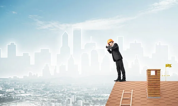Geschäftsmann in Anzug und Helm auf Dachkante — Stockfoto