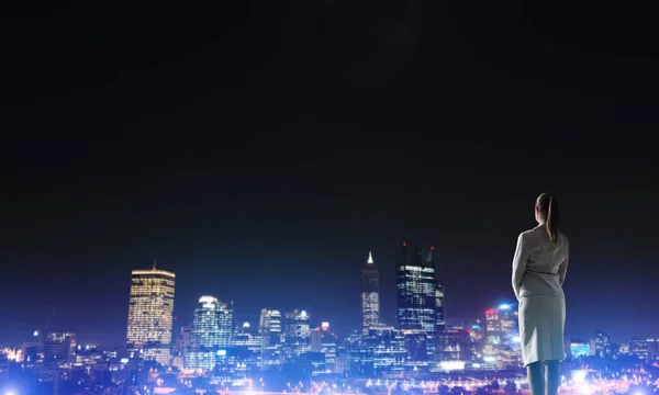 Kvinna som tittar på natten staden — Stockfoto