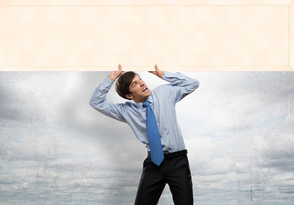 Businessman lifting empty banner — Stock Photo, Image