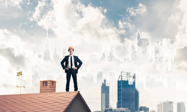 Affärsman i kostym och hjälm på takkanten — Stockfoto
