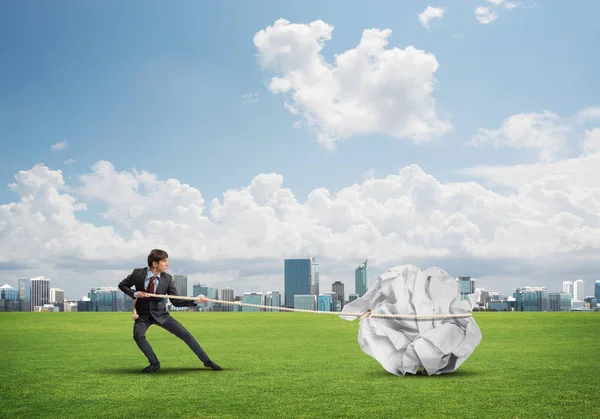 Hombre tirando de gran bola arrugada — Foto de Stock