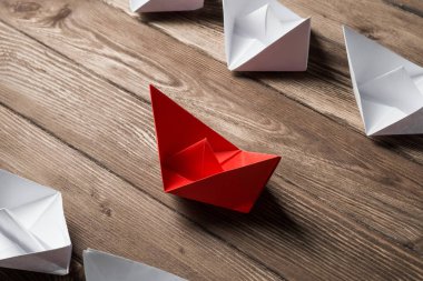 İş liderlik kavramı ile beyaz ve renkli kağıt tekneler ahşap masa üzerinde