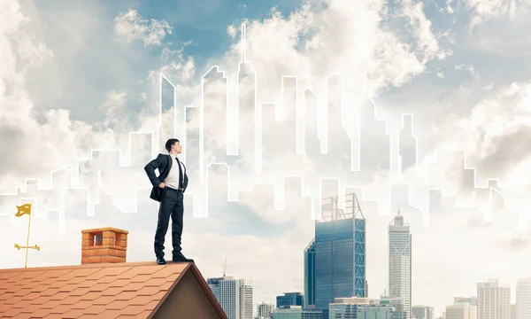 Бизнесмен стоит на крыше дома — стоковое фото