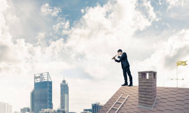 evin çatısında duran işadamı