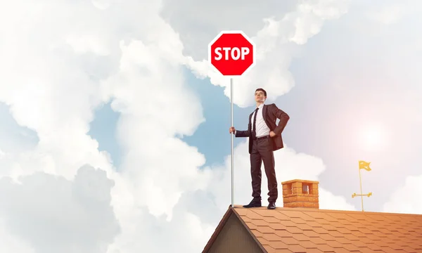 Επιχειρηματίας που στέκεται πάνω σε στέγη σπιτιού — Φωτογραφία Αρχείου