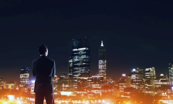 Geschäftsmann sieht Nacht glühende Stadt — Stockfoto