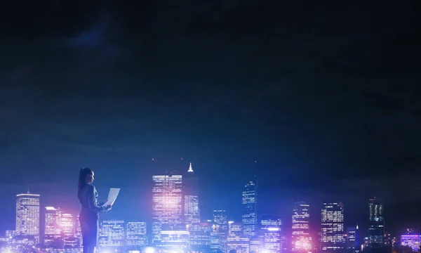 Жінка дивиться на нічне місто — стокове фото