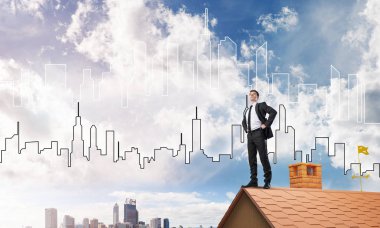 evin çatısında duran işadamı 