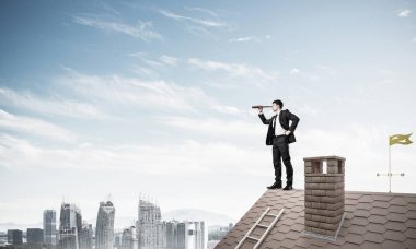 evin çatısında duran işadamı 