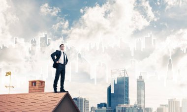 evin çatısında duran işadamı 