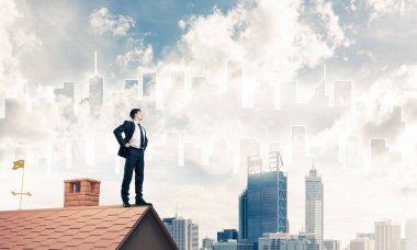 evin çatısında duran işadamı 