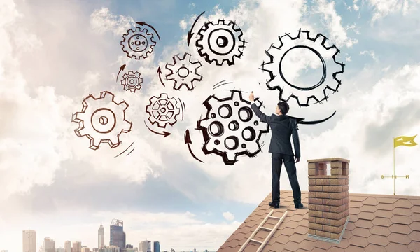 Businessman standing on house roof