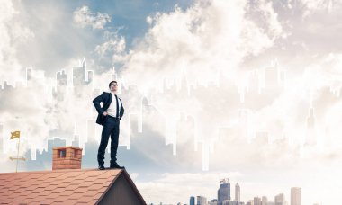 evin çatısında duran işadamı 