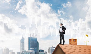 evin çatısında duran işadamı 