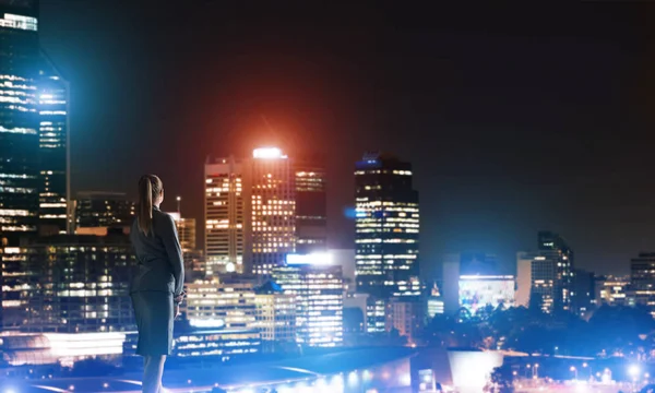 Femme regardant la ville de nuit — Photo