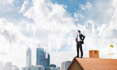 evin çatısında duran işadamı 