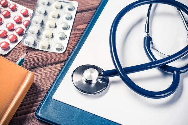 Stethoskop und Medizin auf Holztisch — Stockfoto
