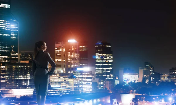 Mujer mirando la ciudad nocturna — Foto de Stock