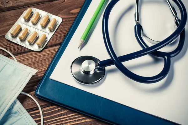 Stethoskop und Medizin auf Holztisch — Stockfoto