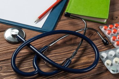 Steteskop ve tıbbi malzeme ahşap masa üstünde 