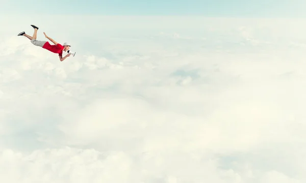 Young cheerful man with megaphone flying — Stock Photo, Image