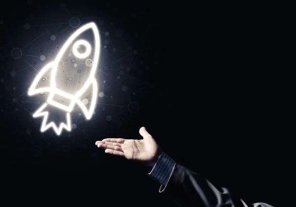 Rocket glowing icon and businessman hand — Stock Photo, Image