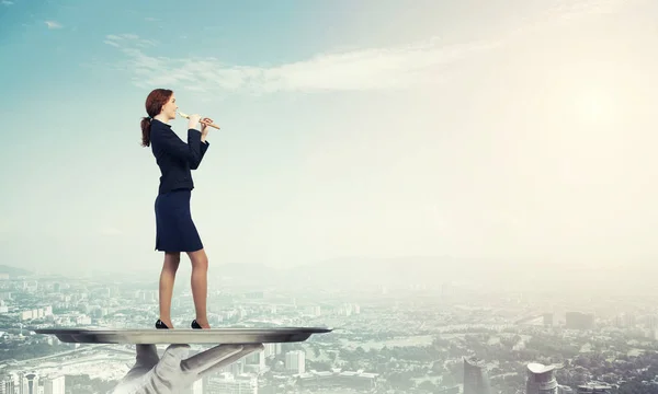 Businesswoman on metal tray playing fife — Stock Photo, Image