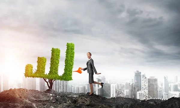 Businesswoman watering plant — Stock Photo, Image