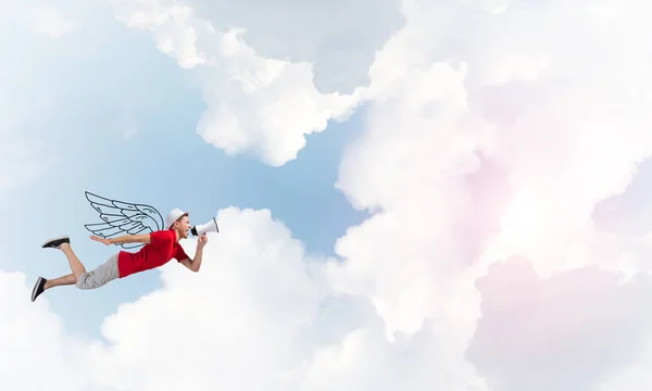 Vrolijke jongeman met megafoon vliegen — Stockfoto