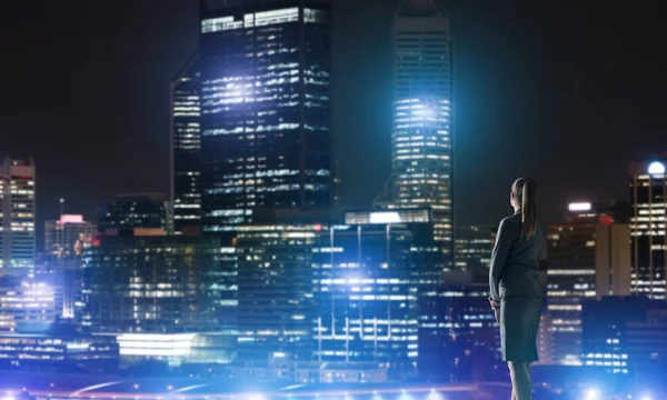 Businesswoman viewing lights of night city — Stock Photo, Image