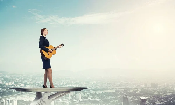 Бізнес-леді на металевому лотку грає на гітарі — стокове фото