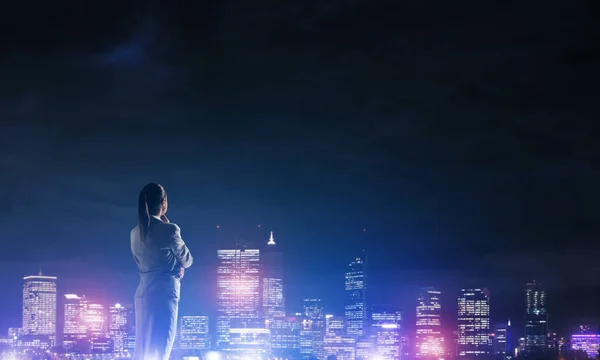 Affärskvinna som tittar på ljus i natten staden — Stockfoto