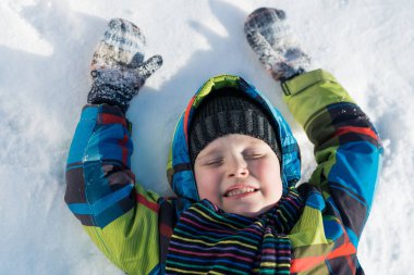sevimli çocuk kar üzerinde yalan