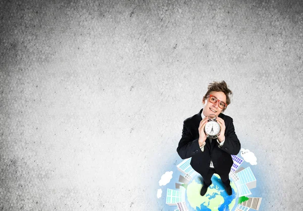 Man standing on globe with alarm clock — Stock Photo, Image