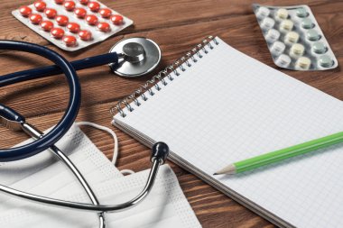 Steteskop ve ahşap masa üzerinde tıbbi nesneleri