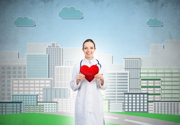 Женщина-врач держит символ сердца — стоковое фото